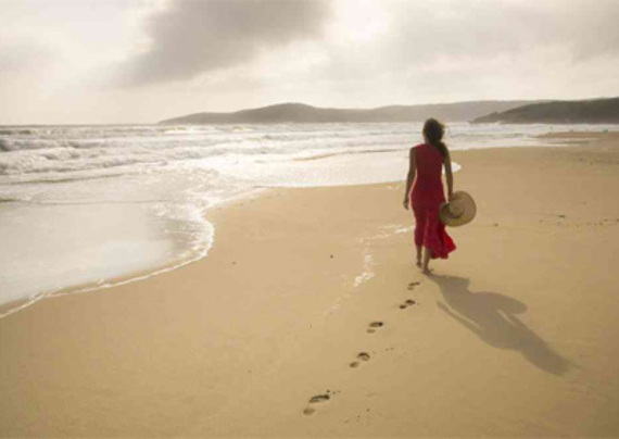 Donna passeggia sulla riva del mare