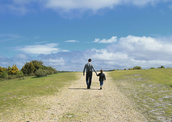 Padre passeggia con suo figlio accompagnandolo per mano