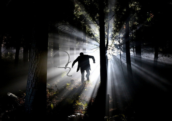 ombra umana nel bosco con laccio e grande luce che filtra